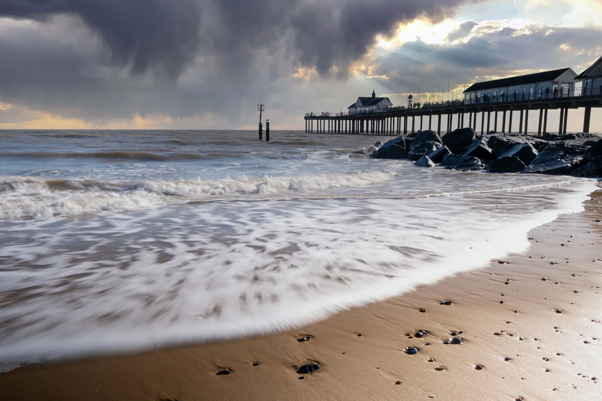 Pier and coastline under a dramatic sky